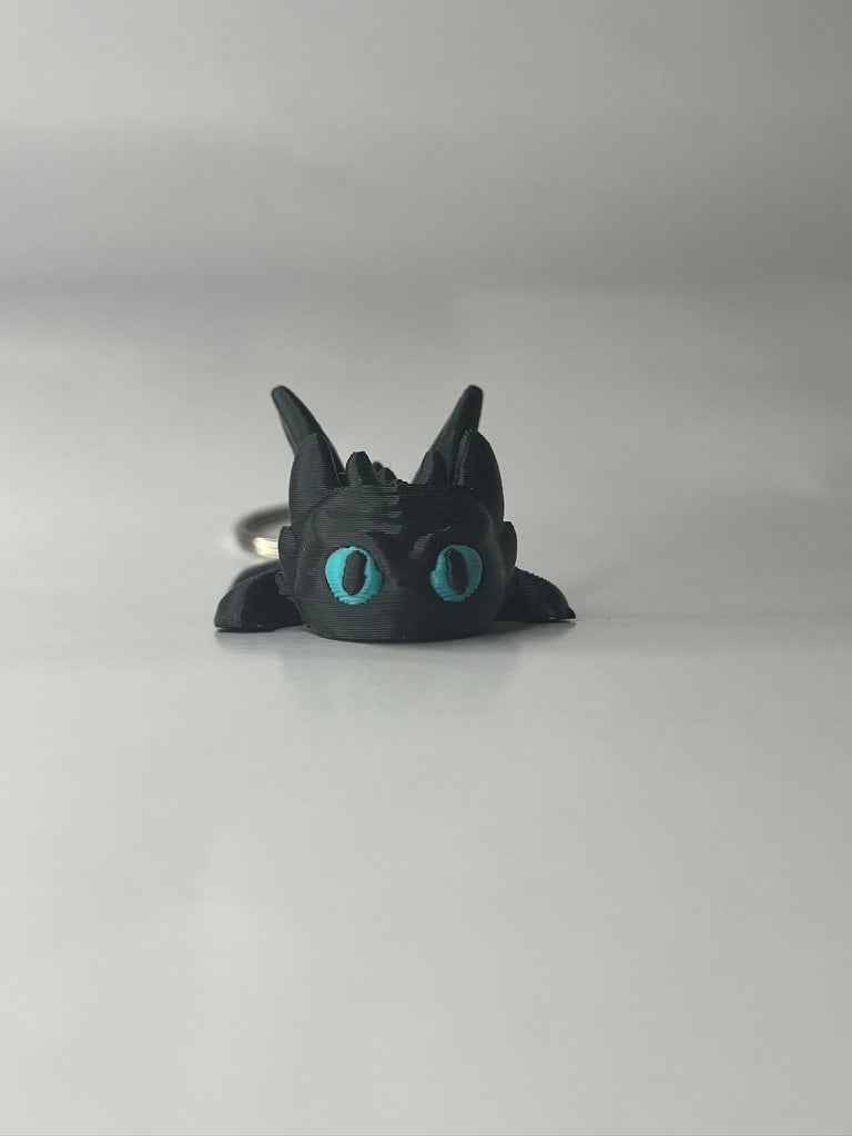 Black dragon-shaped ring with blue eyes on a white background