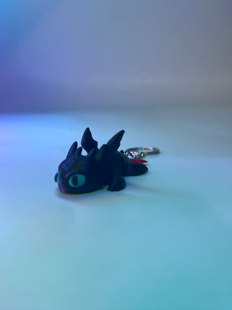 Plush dragon keychain on a gradient blue background