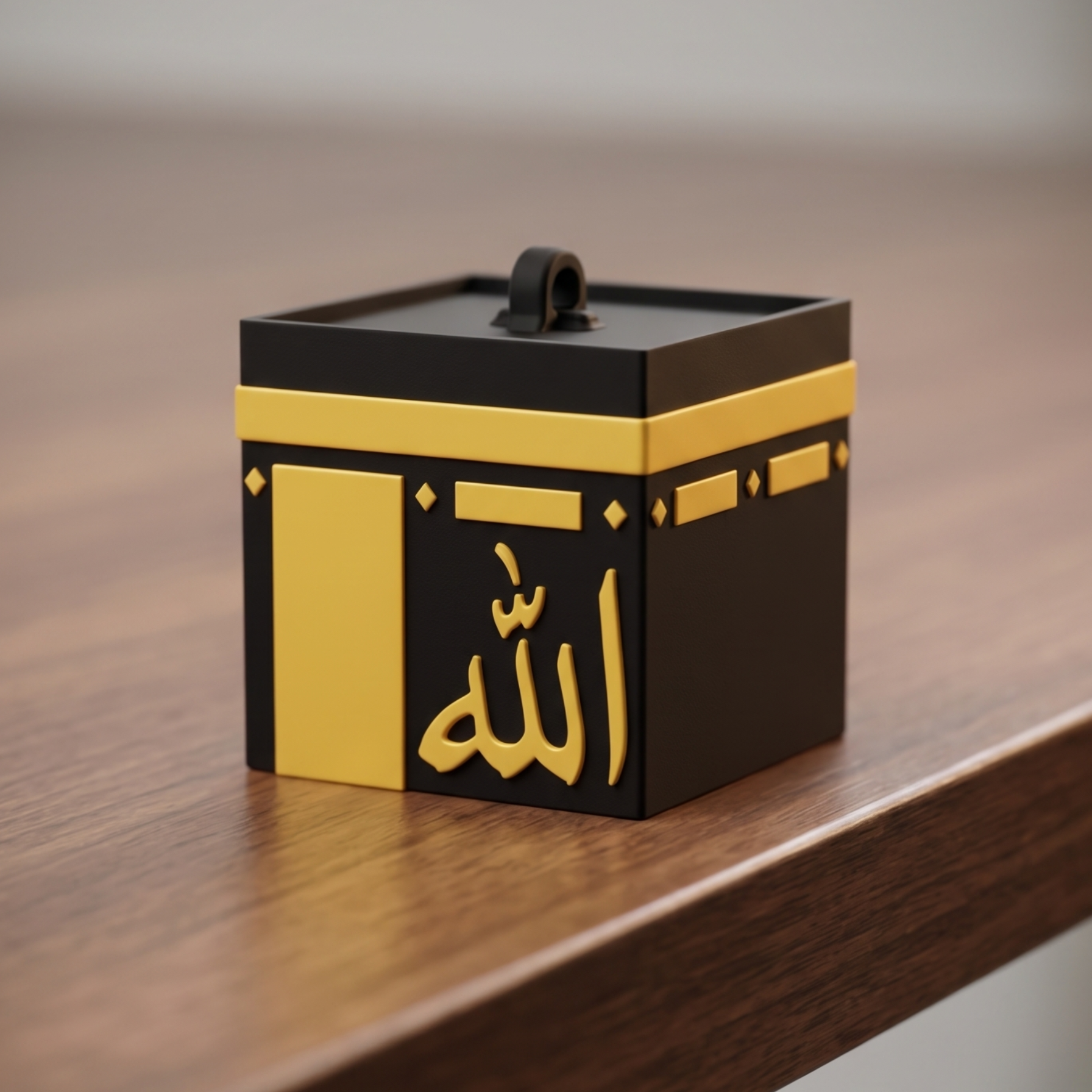 Black and gold decorative box with Arabic text on a wooden surface
