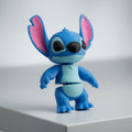 Blue cartoon character figurine with pink inner ears on a white surface